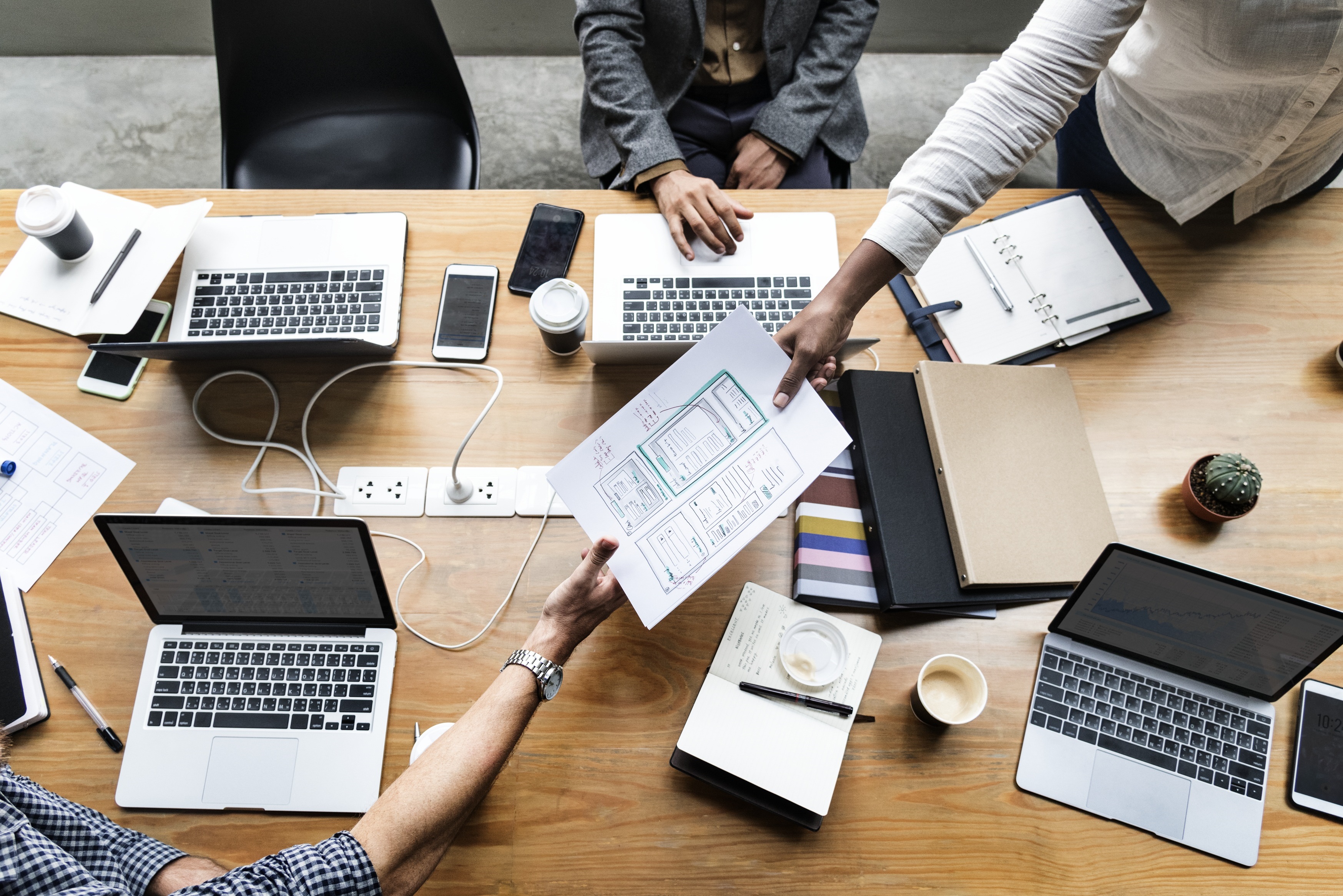 Mesa de trabalho com laptops e documentos de investimento